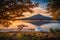 Mt. Fuji over Lake Kawaguchiko with autumn foliage and boat at sunrise in Fujikawaguchiko