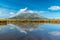 Mt. Taranaki reflected on a pond during a sunny day at New Zealand