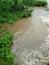 Mud and flowing water reach a pond . swamp during heavy rain looks like water fall causing soil erosion with wave and splash.