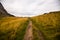 Mud and gravel hiking trail leads through rocky and rugged mountain landscape near the famous tourist hotspot Bunes Beach