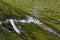 Mud puddle road spring. A rural road in a green field.