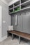 A mud room / entryway with a grey shelving and coat hooks.