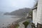 Muddy coast on a misty day: cottages, bare trees, boats at anchor Devon, UK