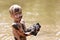 Muddy Little Boy Child Laughing as He Swims and Plays Outside in