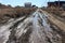 Muddy road with a deep track in the village travel is impossible in a puddle in the summer