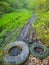 Muddy road in rural path at the forest with creek