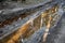 Muddy tracks with puddles on wet muddy surface in forest path