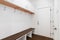 A mudroom with a bench, white cabinets, and coat hooks.