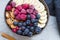 Muesli bowl with berries, banana and almonds, oatmeal breakfast bowl top view with berries