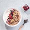 Muesli bowl or granola bowl with yogurt and berries on concrete table top. Healthy breakfast, top view. Dish suitable for diet,