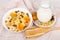 Muesli in bowl, jug milk and bamboo spoon on towel
