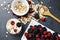 Muesli cereals, yogurt and fresh berries on dark background, preparing a healthy and delicious breakfast with natural ingredients