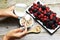 Muesli cereals, yogurt and fresh berries on dark background, preparing a healthy and delicious breakfast with natural ingredients
