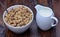 Muesli with chocolate in a ceramic bowl with milk on table