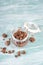 Muesli with chocolate in a glass on a turquoise blue and white shabby background, empty space for text
