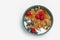 Muesli, isolate on white. Breakfast, healthy food and diet. Muesli with fruits and milk in a plate. Blueberries