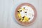 Muesli with on a pink plate, top view. Muesli with fresh milk, yogurt or kefir. Muesli is made from oatmeal, a mixture