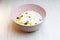 Muesli with on a pink plate, top view. Muesli with fresh milk, yogurt or kefir. Muesli is made from oatmeal, a mixture