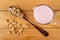 Muesli in spoon, pitcher with yogurt, scattered granola on wooden table. Top view