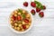 Mueslis with berries in a  white cup on the table, macro