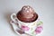Muffin in a cup with a scoop of chocolate ice cream and star shaped sprinkles