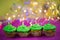 Muffin with green buttercream, pink background, candle