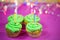 Muffin with green buttercream, pink background, candle