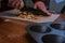 A muffin tray on a table with mixed nuts being chopped