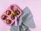 Muffins in a pink cupcake shape, a kitchen spatula with a pink handle, a gray striped towel on a pink background.