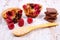 Muffins with raspberries, chocolate and oat bran on spoon, wooden background, delicious dessert