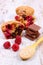 Muffins with raspberries, chocolate and oat bran on spoon, wooden background, delicious dessert