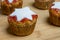 Muffins with red strawberry marmelade and white start placed on wooden board