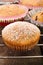 Muffins topped with powdery sugar on a wooden background