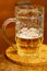 Mug beer half on a wooden stand on a blurred background holiday holiday drink hop