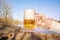 Mug of beer in hand on the background of the river .