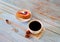 Mug of black coffee on a napkin with anise and a biscuit cake saucer