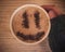 Mug of cappuccino with cinnamon for breakfast.Cinnamon powder in form of a smiley face on coffee foam.