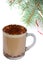 Mug of capuccino under fir-tree branch on white