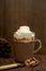 A mug of cocoa and cream, spoon with sugar roasted almonds