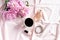 Mug of coffee, bouquet of peonies, women cosmetics and accessories