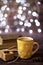 Mug of coffee, cookies, star anise, cinnamon, old books. Blurred lights, wooden background. Winter time, Rustic background