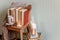 Mug with coffee and home decor on wooden chair. Warm sweater old books, candles, seasonal fall autumn winter weekend concept, copy