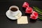 Mug of coffee and marshmallows, clean postcard, three pink tulips. Black background