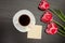 Mug of coffee and marshmallows, clean postcard, three pink tulips. Black background. top view