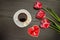 Mug of coffee, marshmallows and heartshaped gingerbread, three pink tulips. Black background