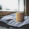 Mug decorated with yellow geometrical elements on a wool sweater in front of a sash window.