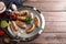 Mug of delicious beer, grilled sausages and fresh sauces on wooden table