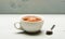 Mug filled with boiling water, teabag and spoon on white background. Mug filled with hot water and dipped bag of black