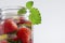 Mug with fruit water with strawberries, mint and lemon, close-up on a white background