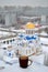 A mug of hot black tea on the background of a blurred winter view of the Parish in honor of the Intercession of the Holy Virgin.